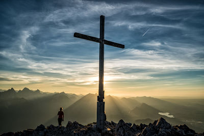 Cross on mountain against sky during sunset