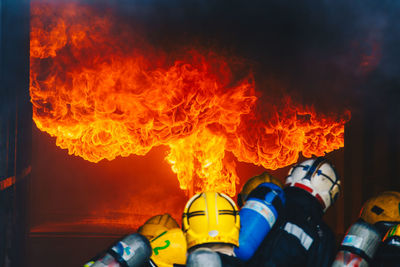 Rear view of firefighters extinguishing fire