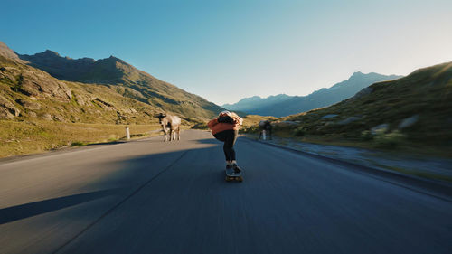 Rear view of people walking on road