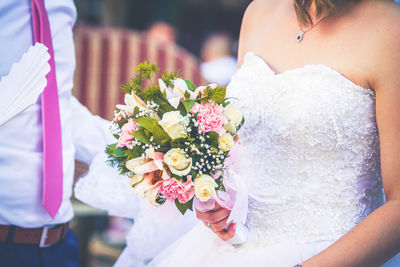 Midsection of woman holding flower bouquet