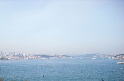 Boats in sea with buildings in background