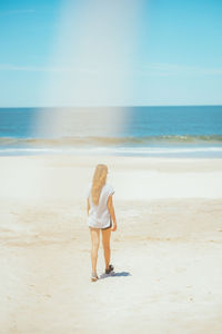 Girl walking on the beach with flare 