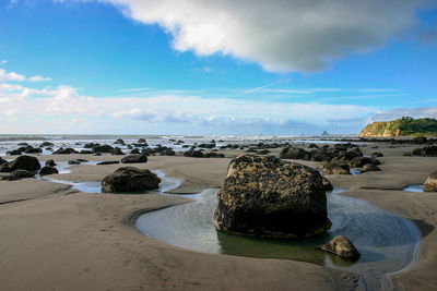 Rocks on beach against sky