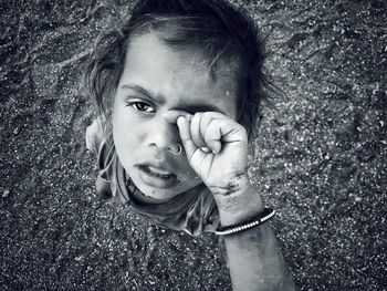 High angle portrait of girl with hands covering eyes standing on ground