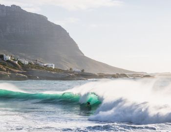 Man surfing in sea against sky