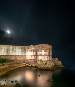 Illuminated castle against sky at night