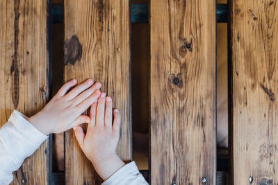 Cropped hands of kid on wooden table