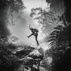 Young woman jumping in swimming pool