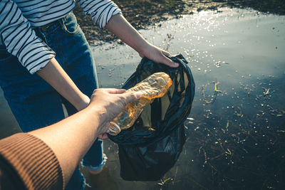 Midsection of man holding fish in lake