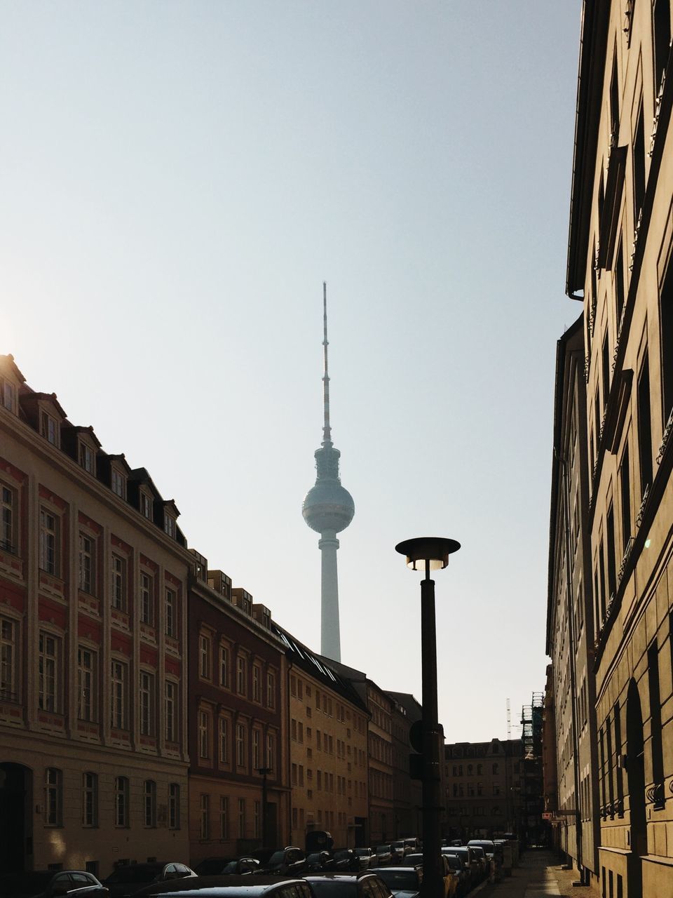 architecture, built structure, building exterior, city, tower, communications tower, famous place, international landmark, travel destinations, capital cities, clear sky, spire, tall - high, fernsehturm, travel, tourism, low angle view, culture, television tower, street light