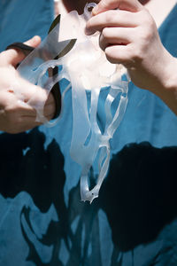 Midsection of woman cutting plastic