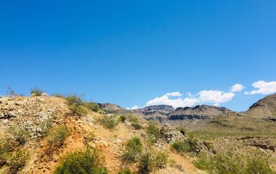 Scenic view of mountains against blue sky