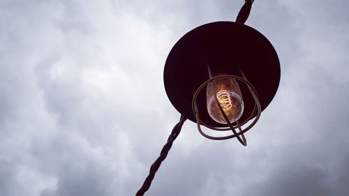 Low angle view of electric lamp against sky