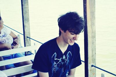 Young man smiling while sitting in ferry boat