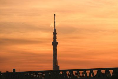 Low angle view of communications tower against sky at sunset