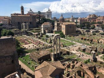 High angle view of old ruin at roman forum against cloudy sky