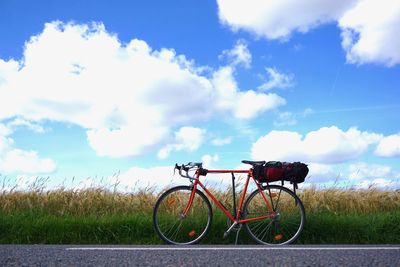 Bicycle on grass against sky