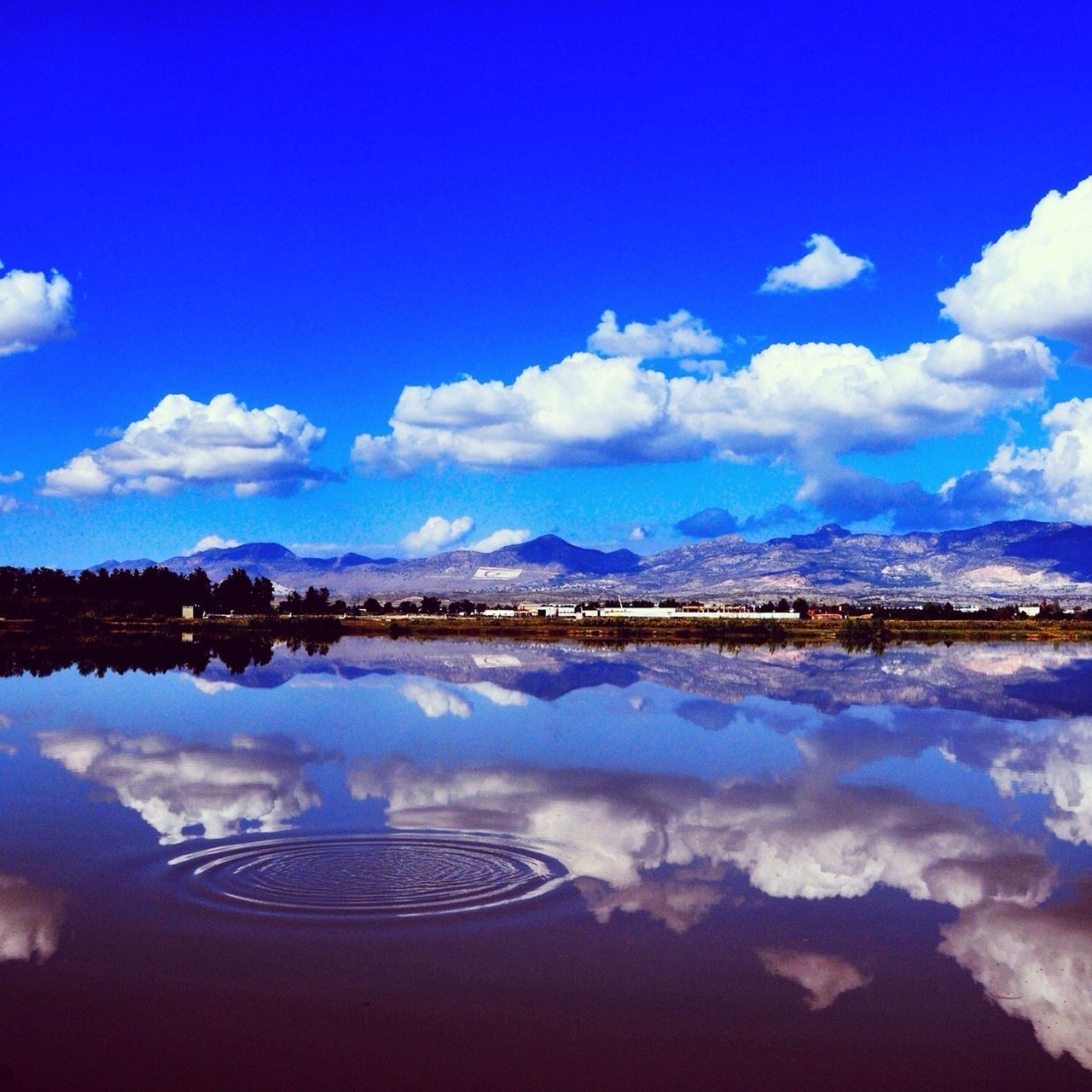 sky, reflection, tranquil scene, blue, water, scenics, tranquility, cloud - sky, lake, beauty in nature, cloud, mountain, nature, waterfront, idyllic, standing water, outdoors, landscape, cold temperature, calm