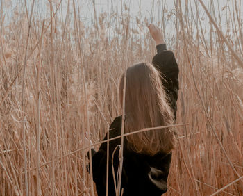 Rear view of woman standing on field