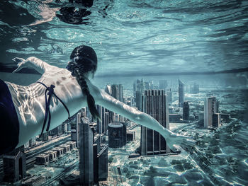 Digital composite image of woman swimming in sea