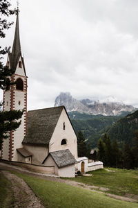 Church by buildings against sky