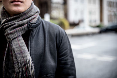 Midsection of man wearing scarf while standing on road