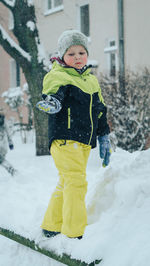 Portrait of cute boy standing in snow