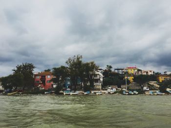 Houses by sea against sky