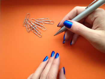 Cropped image of woman's hands with pen and paper clips