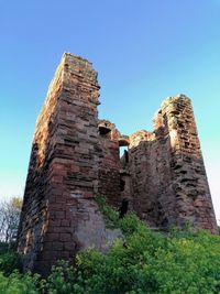 Low angle view of old building against blue sky