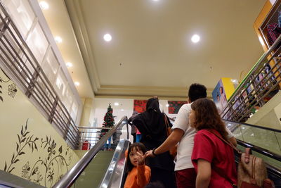 Rear view of people walking on staircase