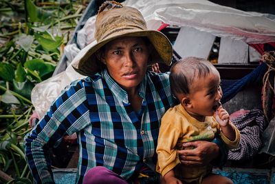 Portrait of mother and daughter sitting outdoors