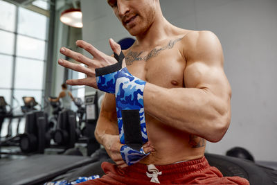 Low angle view of shirtless man exercising in gym