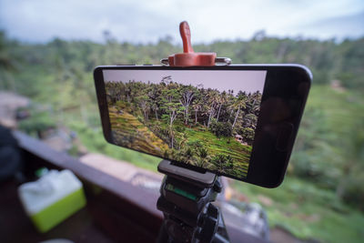 Close-up of camera phone on landscape