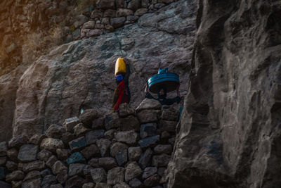 Rear view of man and rocks on rock