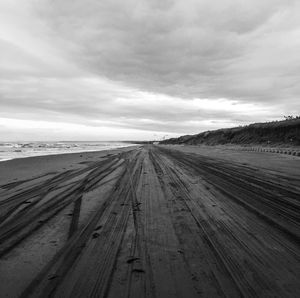 Empty road on field against sky