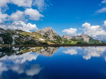 Scenic view of lake and mountains against blue sky