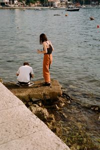 People on pier by river