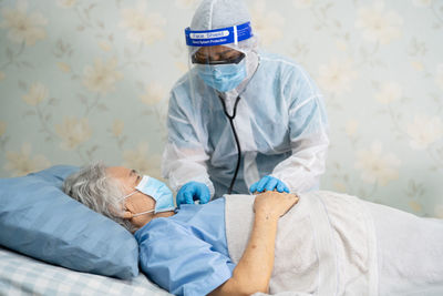 Rear view of man lying on bed