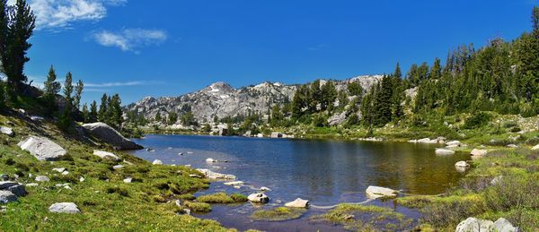 Scenic view of lake and mountains against blue sky