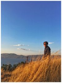 Man standing on field against sky