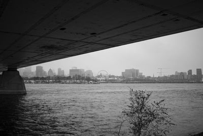 Scenic view of river by buildings against sky