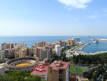 High angle view of cityscape by sea against sky