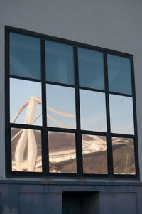 Low angle view of glass building against sky