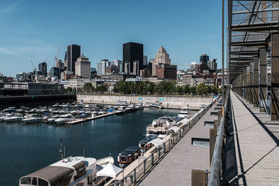 Bridge over river by buildings against sky in city