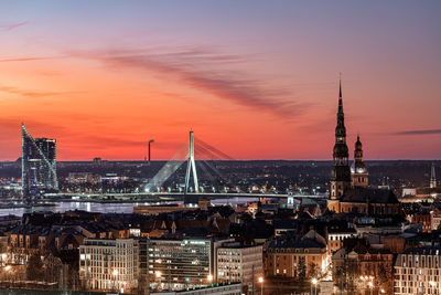 Illuminated buildings in city during sunset