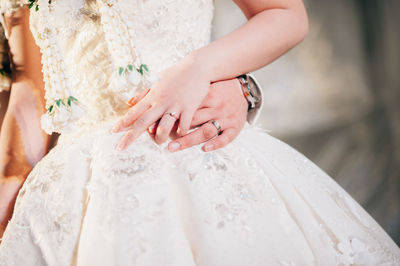 Midsection of bride and groom dancing