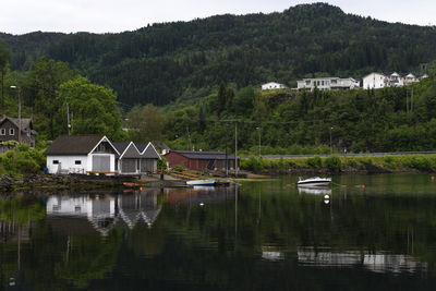 Houses by lake against trees