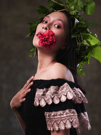 Portrait of woman standing by plant