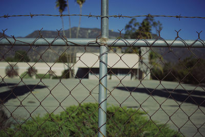 Close-up of barbed wire fence against sky